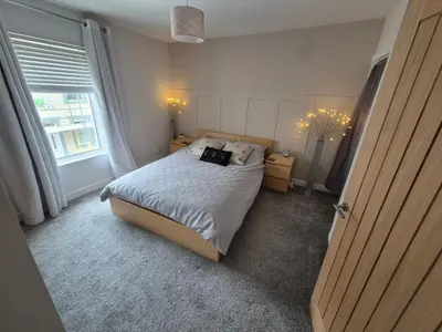 a small bedroom with a bed and a window at Driftwood Cottage in Askam in Furness
