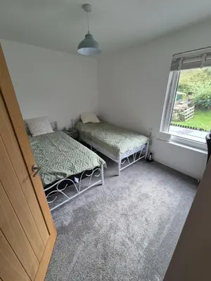 a room with two beds and a window at Driftwood Cottage in Askam in Furness