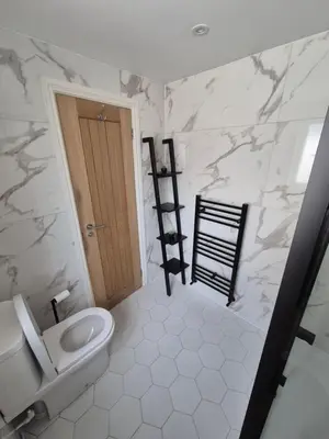 a bathroom with a toilet and a door in it at Driftwood Cottage in Askam in Furness