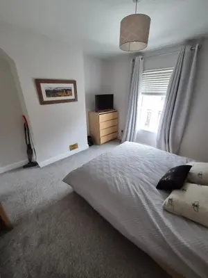 a bedroom with a white bed and a window at Driftwood Cottage in Askam in Furness