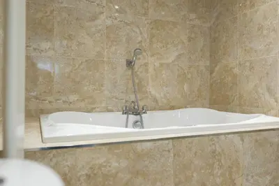 a bath tub with a faucet in a bathroom at Luxury stay in Central Southport in Southport