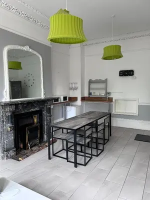 a dining room with a table and a fireplace at Green-Lodge Triple Double & Single Rooms Near LFC Anfield Free Street Parking 24-7 in Liverpool