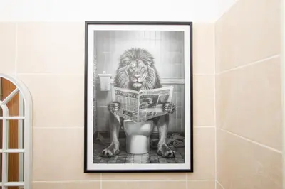 a picture of a lion reading a newspaper in a bathroom at Cosy Studio Near Goodison & Anfield, Liverpool in Liverpool