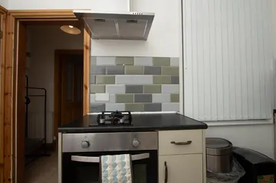 a kitchen with a sink and a stove at Cosy Studio Near Goodison & Anfield, Liverpool in Liverpool