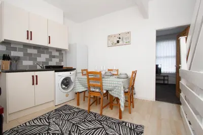a kitchen and dining room with a table and chairs at Cosy Studio Near Goodison & Anfield, Liverpool in Liverpool