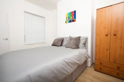a white bedroom with a bed and a window at Cosy 2BR Flat Near Anfield & Goodison, Liverpool in Liverpool