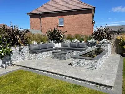 a garden with two benches and a brick building at Luxury 3 Bedroom Home - 15mins to Birkdale Open in Formby