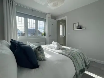 a bedroom with a large white bed with pillows at Luxury 3 Bedroom Home - 15mins to Birkdale Open in Formby