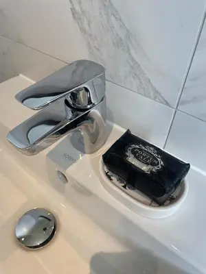 a bathroom sink with a faucet and a black bag on it at Luxury 3 Bedroom Home - 15mins to Birkdale Open in Formby