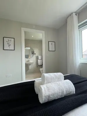 a bedroom with a bed with two towels on it at Luxury 3 Bedroom Home - 15mins to Birkdale Open in Formby