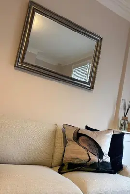 a mirror on the wall above a couch in a room at Beautiful 2 bedroom house in the heart of Lytham in Lytham St Annes