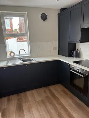a kitchen with black cabinets and a sink and a window at Beautiful 2 bedroom house in the heart of Lytham in Lytham St Annes