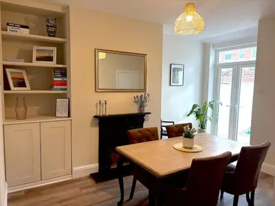 a dining room with a table and a mirror at Beautiful 2 bedroom house in the heart of Lytham in Lytham St Annes