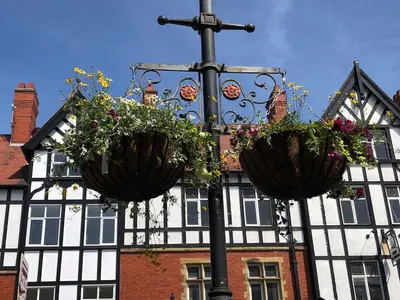 two flower baskets on a street light in front of a building at Beautiful 2 bedroom house in the heart of Lytham in Lytham St Annes