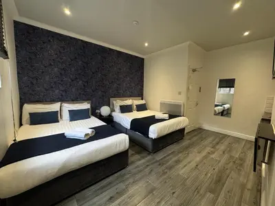 a hotel room with two beds and a large wall at Bold Street Studio IV in Liverpool