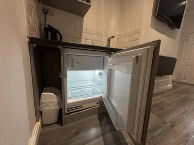 an empty refrigerator with its door open in a kitchen at Bold Street Studio IV in Liverpool