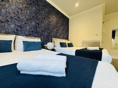 a bedroom with two beds with blue and white pillows at Bold Street Studio IV in Liverpool