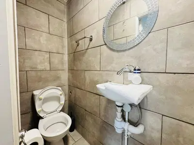a bathroom with a toilet and a sink and a mirror at Bold Street Studio VIII in Liverpool