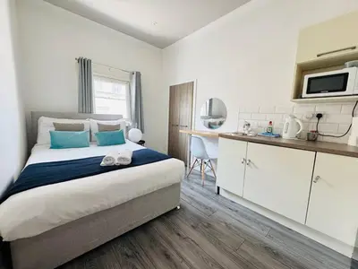 a bedroom with a large bed and a kitchen at Bold Street Studio VIII in Liverpool