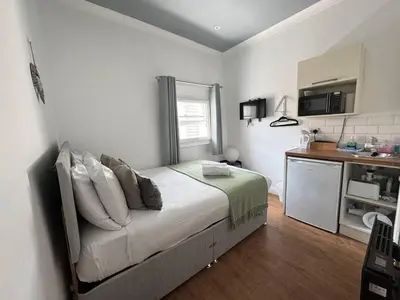 a small bedroom with a bed and a kitchen at Bold Street Studio VII in Liverpool