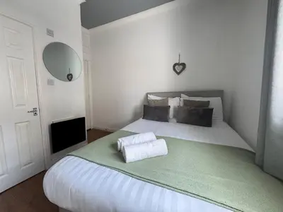 a bedroom with a large bed with a green blanket at Bold Street Studio VII in Liverpool