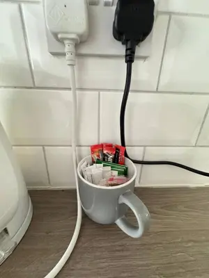 a coffee cup with a cord plugged into a phone at Bold Street Studio VII in Liverpool