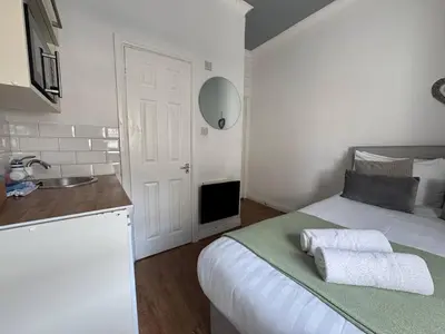 a white bedroom with a bed and a sink at Bold Street Studio VII in Liverpool