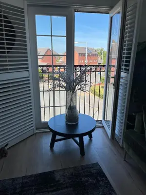 a vase on a table in front of a window at 2 Bed Modern Apartment in Haydock