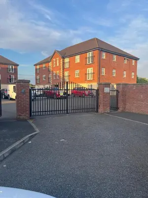 a black gate in front of a brick building at 2 Bed Modern Apartment in Haydock