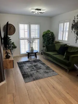 a living room with a green couch and a table at 2 Bed Modern Apartment in Haydock