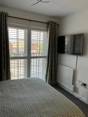 a bedroom with a bed and a large window at 2 Bed Modern Apartment in Haydock