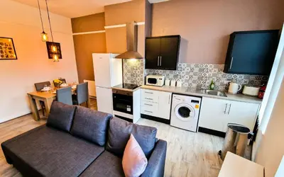 a living room with a couch and a kitchen at Lodginet Stays - County Cosy - 1BR Flat 2 in Liverpool