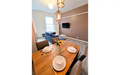 a dining room and living room with a wooden table at Lodginet Stays - County Cosy - 1BR Flat 2 in Liverpool