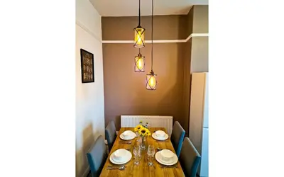 a dining room table with plates and flowers on it at Lodginet Stays - County Cosy - 1BR Flat 2 in Liverpool