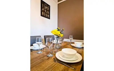 a dining room table with plates and wine glasses at Lodginet Stays - County Cosy - 1BR Flat 2 in Liverpool