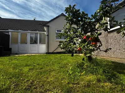 an apple tree in the yard of a house at Chic 2-Bed Loft Bungalow, Cleveleys, Near Beach in Blackpool