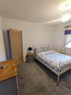 a bedroom with a bed and a table and a door at Chic 2-Bed Loft Bungalow, Cleveleys, Near Beach in Blackpool