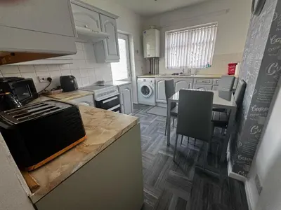 a kitchen with a counter and a table with chairs at Chic 2-Bed Loft Bungalow, Cleveleys, Near Beach in Blackpool