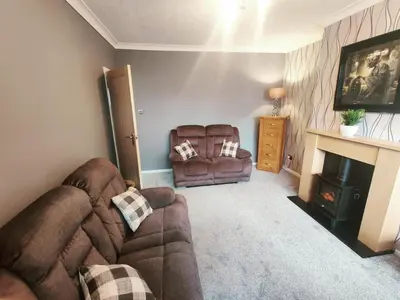 a living room with a couch and a fireplace at Chic 2-Bed Loft Bungalow, Cleveleys, Near Beach in Blackpool