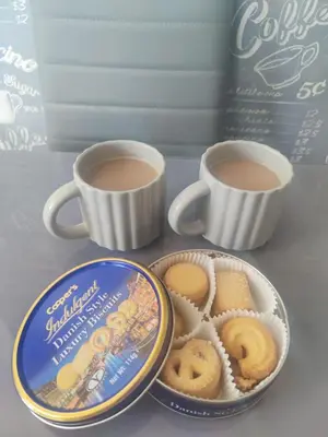 two cups of coffee and a box of cookies at Chic 2-Bed Loft Bungalow, Cleveleys, Near Beach in Blackpool