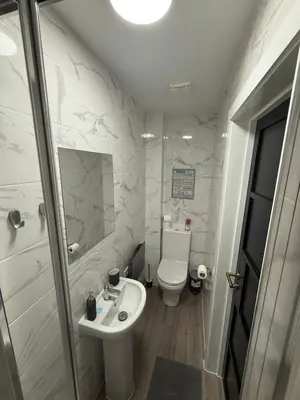 a white bathroom with a toilet and a sink at Stylish and Bright 2 Bedroom Flat Free Parking in Wallasey