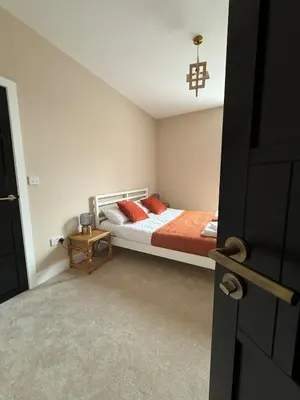 a bedroom with a bed with red pillows on it at Stylish and Bright 2 Bedroom Flat Free Parking in Wallasey