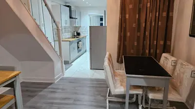 a kitchen with a table and chairs in a room at A home away- 2 bedrooms in Saint Helens