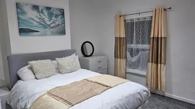 a bedroom with a bed and a window at A home away- 2 bedrooms in Saint Helens