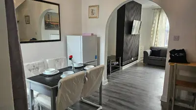 a kitchen with a table with chairs and a refrigerator at A home away- 2 bedrooms in Saint Helens