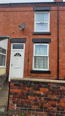 a brick house with a white door and two windows at A home away- 2 bedrooms in Saint Helens