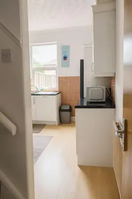a kitchen with white cabinets and a counter top at Cosy Two-Bedroom House in Ormskirk in Pemberton