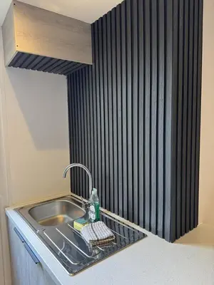 a sink in a kitchen with a black wall at Blackpool Abode - Suites by the Sea in Blackpool