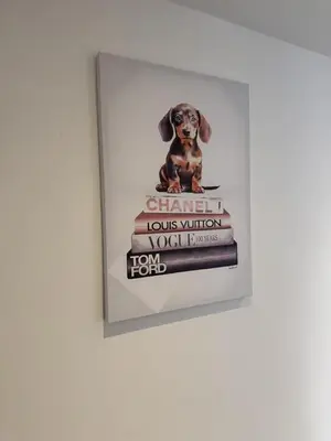 a picture of a dog sitting on a stack of books at Blackpool Abode - Suites by the Sea in Blackpool
