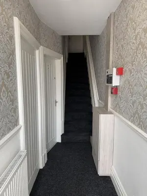a hallway with a staircase in a house with a stair case at Blackpool Abode - Suites by the Sea in Blackpool